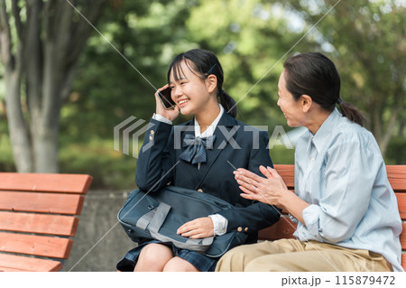 電話で朗報を受ける制服姿・ブレザー姿の女子中学生・女子高校生と母親・教師・先生の女性 115879472