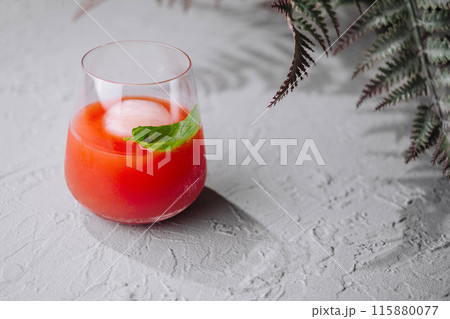 Refreshing tomato cocktail with basil garnish 115880077