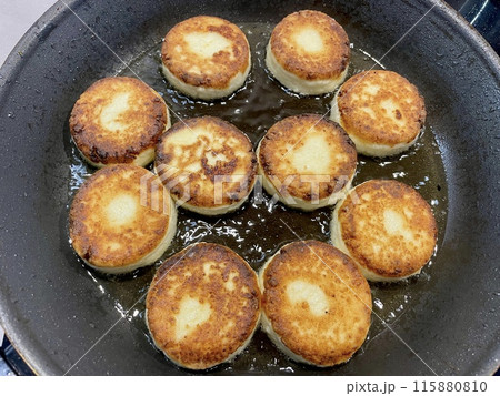 Round sweet cheesecakes are fried in a pan for breakfast Round sweet cheesecakes are fried in a pan for breakfast 115880810