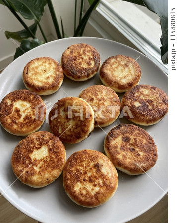 Fried, browned cheesecakes are prepared on a gray bowl 115880815