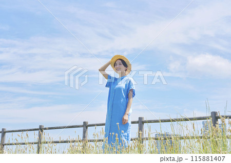 屋外で麦わら帽子をかぶった女性のポートレート 115881407