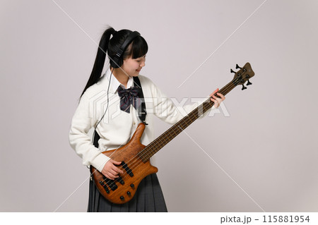 ヘッドフォンをしてベースを弾く女子高生　  115881954