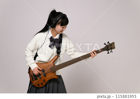 ヘッドフォンをしてベースを弾く女子高生　  115881955
