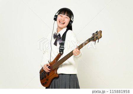 ヘッドフォンをしてベースを弾く女子高生　  115881958