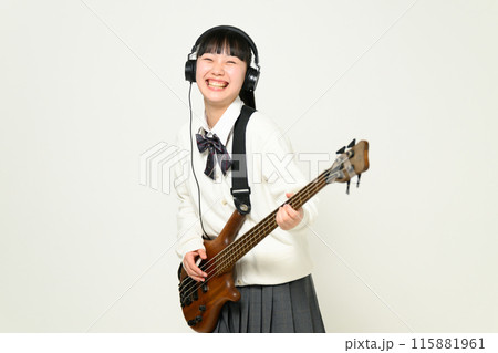 ヘッドフォンをしてベースを弾く女子高生　  115881961