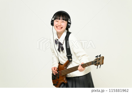 ヘッドフォンをしてベースを弾く女子高生　  115881962