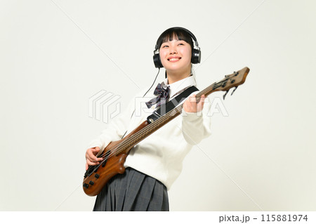 ヘッドフォンをしてベースを弾く女子高生　  115881974