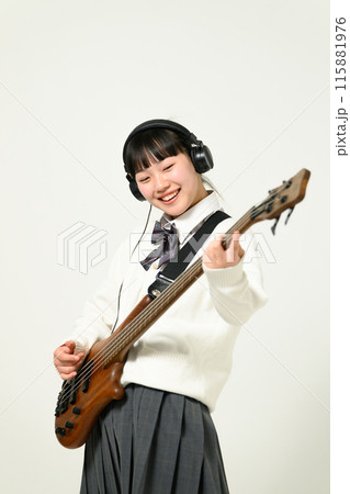 ヘッドフォンをしてベースを弾く女子高生　  115881976