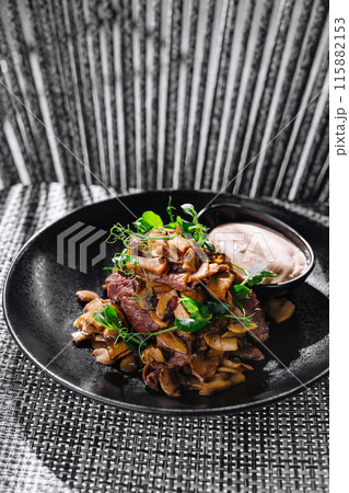 Gourmet fried mushrooms with beef steak and dip on elegant plate 115882153