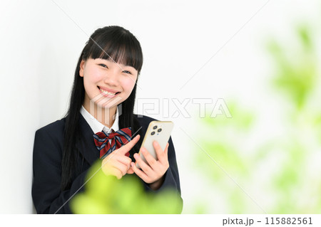 壁に寄り掛かりスマホを操作する女子高生 壁に寄り掛かりスマホを操作する女子高生 115882561