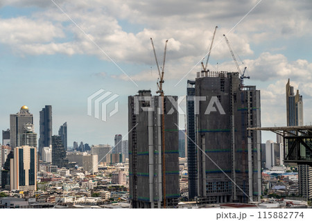 Timelapse view of big construction cranes working on top of high-rise buildings in Bangkok, Thailand with moving clouds and high-rises buildings in background Timelapse view of big construction cranes working on top of high-rise buildings in Bangkok, Thailand with moving clouds and high-rises buildings in background 115882774
