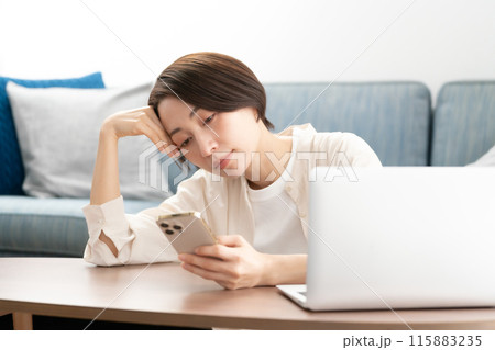 スマホを見るアラフォー女性 スマホを見るアラフォー女性 115883235