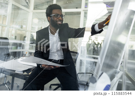 Dark-skinned architect working in his office on a new project Dark-skinned architect working in his office on a new project 115883544