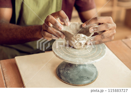 Close up of mans hands molding a shape of clay Close up of mans hands molding a shape of clay 115883727