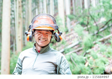 伐採した現場をバックに満面の笑みでこちらを向いているフォレストワーカー 115884997