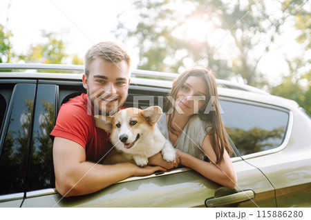 Lovely young couple with dog sits in back seat of car. Concept of active lifestyle, weekend, relax. 115886280