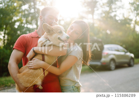Young couple together with their beloved pet on walk. Domestic dog concept. Active lifestyle concept Young couple together with their beloved pet on walk. Domestic dog concept. Active lifestyle concept 115886289