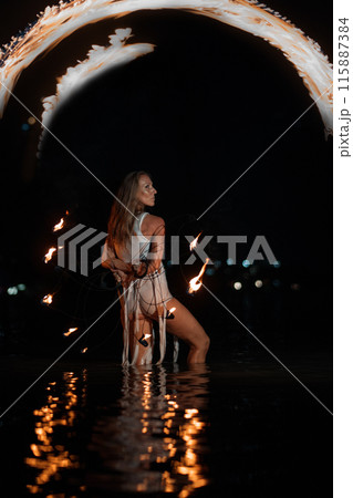 Caucasian woman dancing with fire in the water. Fire show at sea. Acrobatics on the beach. Yoga and relaxation at sunset. Spectacular circus performance. model body. High quality FullHD footage.  115887384