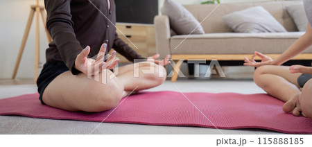 Lesbian Couple Practicing Yoga Together at Home, Engaging in Stretching Exercises on a Pink Mat in a Modern Living Room Lesbian Couple Practicing Yoga Together at Home, Engaging in Stretching Exercises on a Pink Mat in a Modern Living Room 115888185