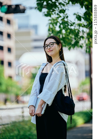 パソコンを持って歩く若い女性 パソコンを持って歩く若い女性 115888869