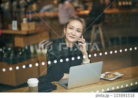 mid adult asian businesswoman working in coffee shop mid adult asian businesswoman working in coffee shop 115891518