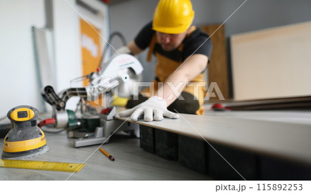 Male master is engaged in laying laminate 115892253