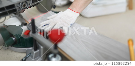 Builder cuts laminate board with circular saw 115892254