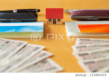 2つの通帳とはんこ、一万円札と家 お金イメージ 115892419
