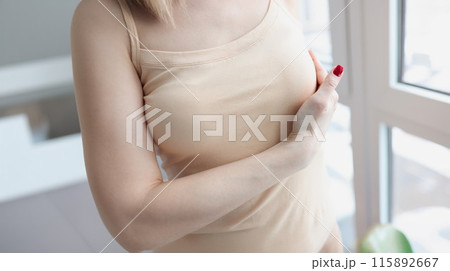 Woman hand examining mammary gland at home closeup 115892667