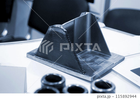 Object printed by 3D printer from metal. Additive manufacturing solution. Object created on 3Dprinter from melting metal thread. 3D Metal Printing. Metal additive manufacturing Object printed by 3D printer from metal. Additive manufacturing solution. Object created on 3Dprinter from melting metal thread. 3D Metal Printing. Metal additive manufacturing 115892944