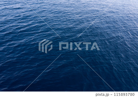 sun glare on the surface of blue sea water 115893780