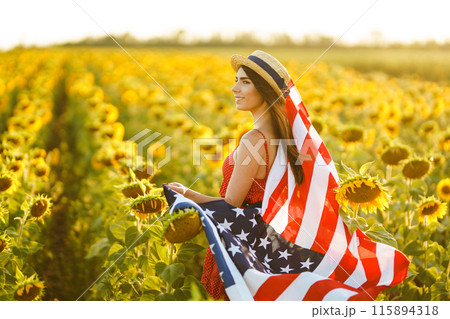Beautiful girl in hat with the American flag in a sunflower field. 4th of July. Fourth of July. Freedom Beautiful girl in hat with the American flag in a sunflower field. 4th of July. Fourth of July. Freedom 115894318