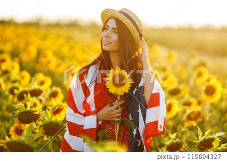 Beautiful girl in hat with the American flag in a sunflower field. 4th of July. Fourth of July. Freedom Beautiful girl in hat with the American flag in a sunflower field. 4th of July. Fourth of July. Freedom 115894327