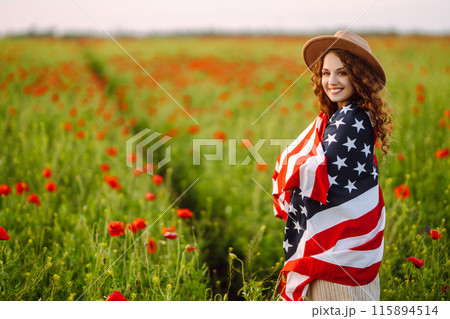 Young woman hold waving american USA flag in in the poppy field. Independence Day, 4th July. 115894514