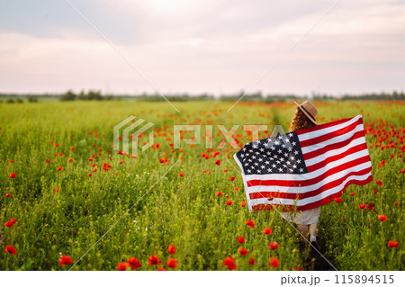 Young woman hold waving american USA flag in in the poppy field. Independence Day, 4th July. 115894515
