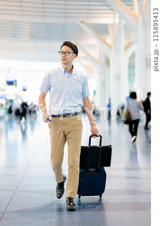 空港内のロビーを歩く男性 115895413