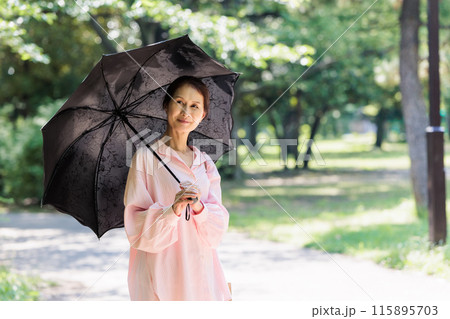 日傘をさして散歩するミドル女性 115895703