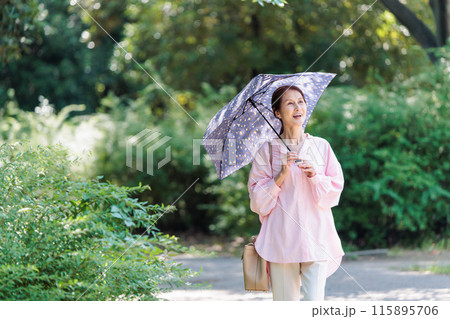 日傘をさして散歩するミドル女性 115895706