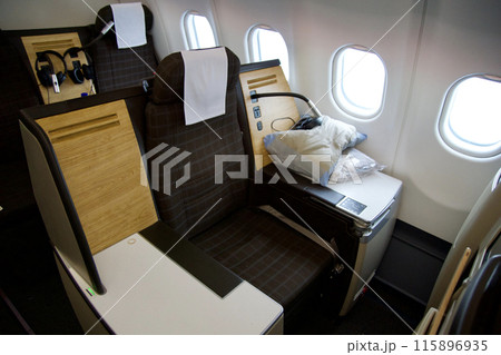 ZURICH, SWITZERLAND - JUNE 22, 2019: Empty cabin with business class seats with wood applications and brown fabric in a long-haul aircraft on the flight from Dubai to Zurich 115896935