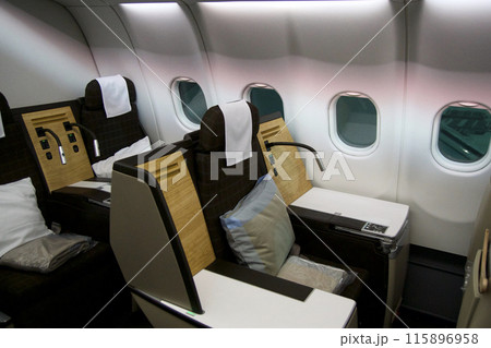 ZURICH, SWITZERLAND - JUNE 22, 2019: Empty cabin with business class seats with wood applications and brown fabric in a long-haul aircraft on the flight from Dubai to Zurich 115896958