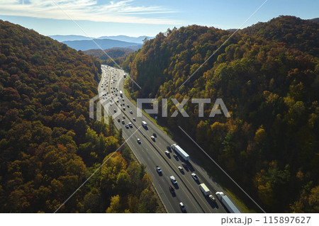 View from above of I-40 freeway in North Carolina heading to Asheville through Appalachian mountains in golden fall season with fast driving trucks and cars. Interstate transportation concept View from above of I-40 freeway in North Carolina heading to Asheville through Appalachian mountains in golden fall season with fast driving trucks and cars. Interstate transportation concept 115897627