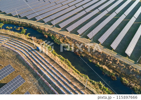 Aerial view of large sustainable electrical power plant with rows of solar photovoltaic panels for producing clean ecological electric energy. Renewable electricity with zero emission concept Aerial view of large sustainable electrical power plant with rows of solar photovoltaic panels for producing clean ecological electric energy. Renewable electricity with zero emission concept 115897666