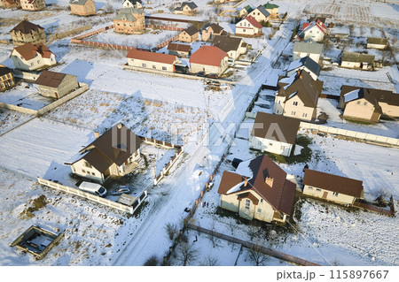 Aerial view of residential houses with snow covered roofops in suburban rural town area in winter 115897667