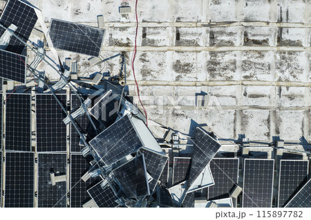 Consequences of natural disaster. Damaged by hurricane wind photovoltaic solar panels mounted on industrial building roof for producing green ecological electricity 115897782