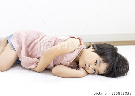 絨毯に寝転がる笑顔の女の子（3歳、日本人、ショートヘア） 115898033