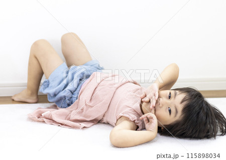 絨毯に寝転がる笑顔の女の子（3歳、日本人、ショートヘア） 115898034