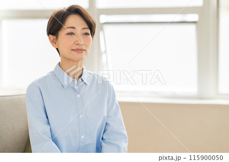 リビングで寛ぐミドル女性。 リビングで寛ぐミドル女性。 115900050