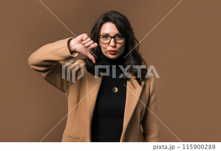 Mature woman with sign of dislike. Stylish lady showing thumbs-down, dont like Mature woman with sign of dislike. Stylish lady showing thumbs-down, dont like 115900289