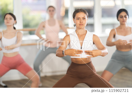 Young woman leading amateur ballet class in studio Young woman leading amateur ballet class in studio 115902721