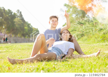 Girl is resting on her boyfriend's lap Girl is resting on her boyfriend's lap 115902784